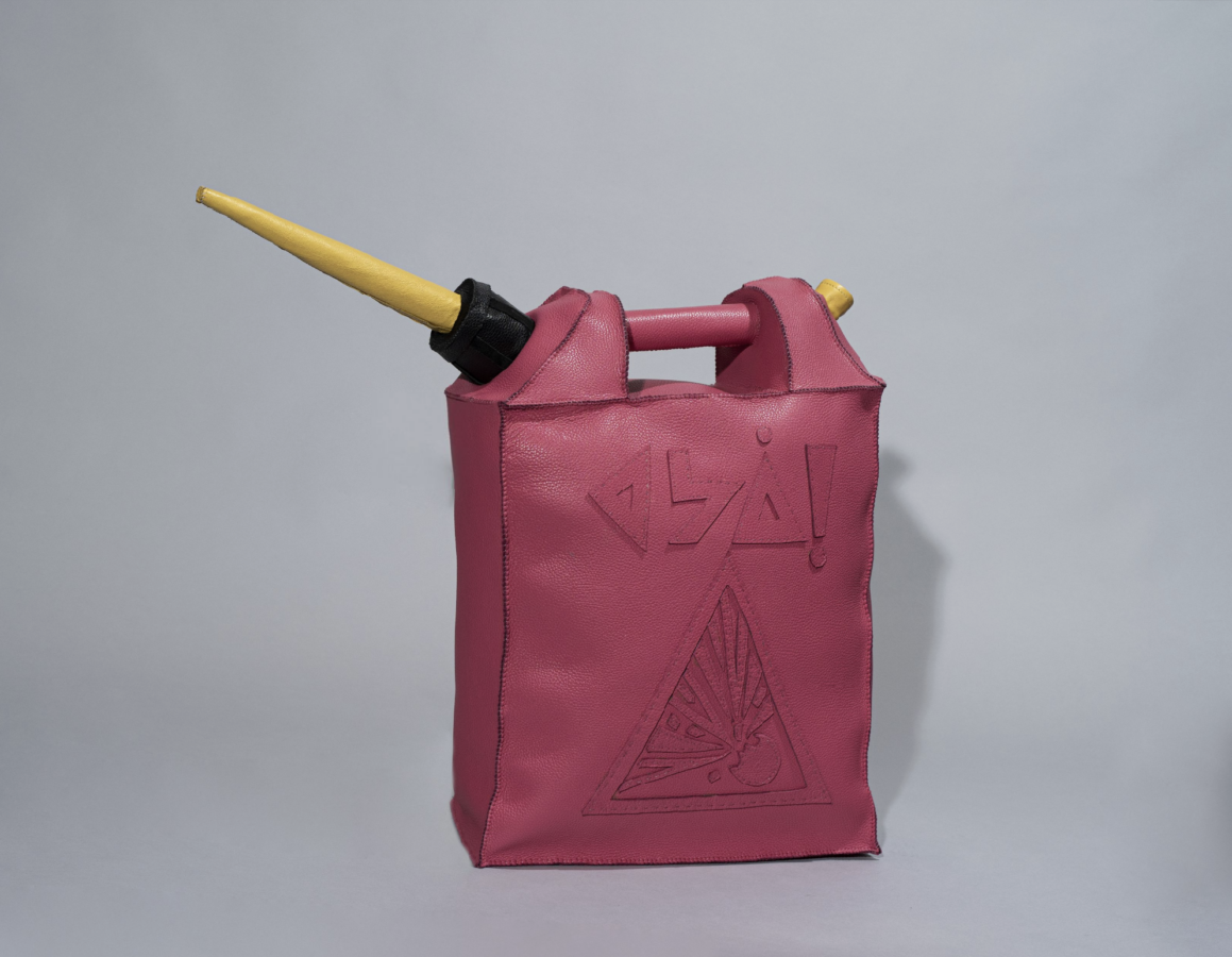 A pink leather bag designed to look like a gas can, featuring a triangular explosion warning symbol and abstract symbols embossed above. It has a black cap and a long yellow spout.
